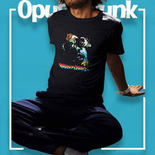Load image into Gallery viewer, guy-sitting-and-wearing-a-black-t-shirt-with-a-face-and-text-on-the-front

