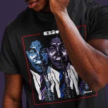 Load image into Gallery viewer, man-wearing-black-t-shirt-with-graphic-with-guy-blowing-a-saxophone-the-front
