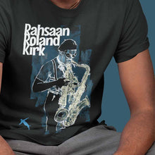Load image into Gallery viewer, guy-sitting-and-wearing-a-black-t-shirt-with-a-saxophone-player-on-the-front
