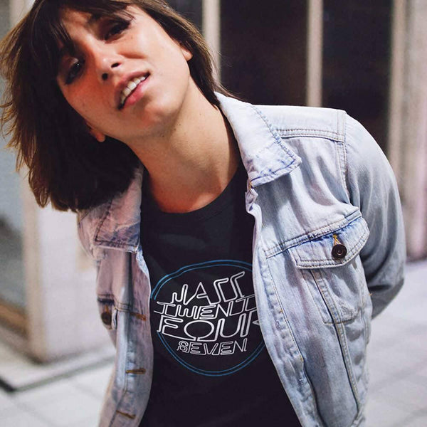 young girl having fun while wearing a round neck jazz24-7 tee and a denim jacket on top near closed stores